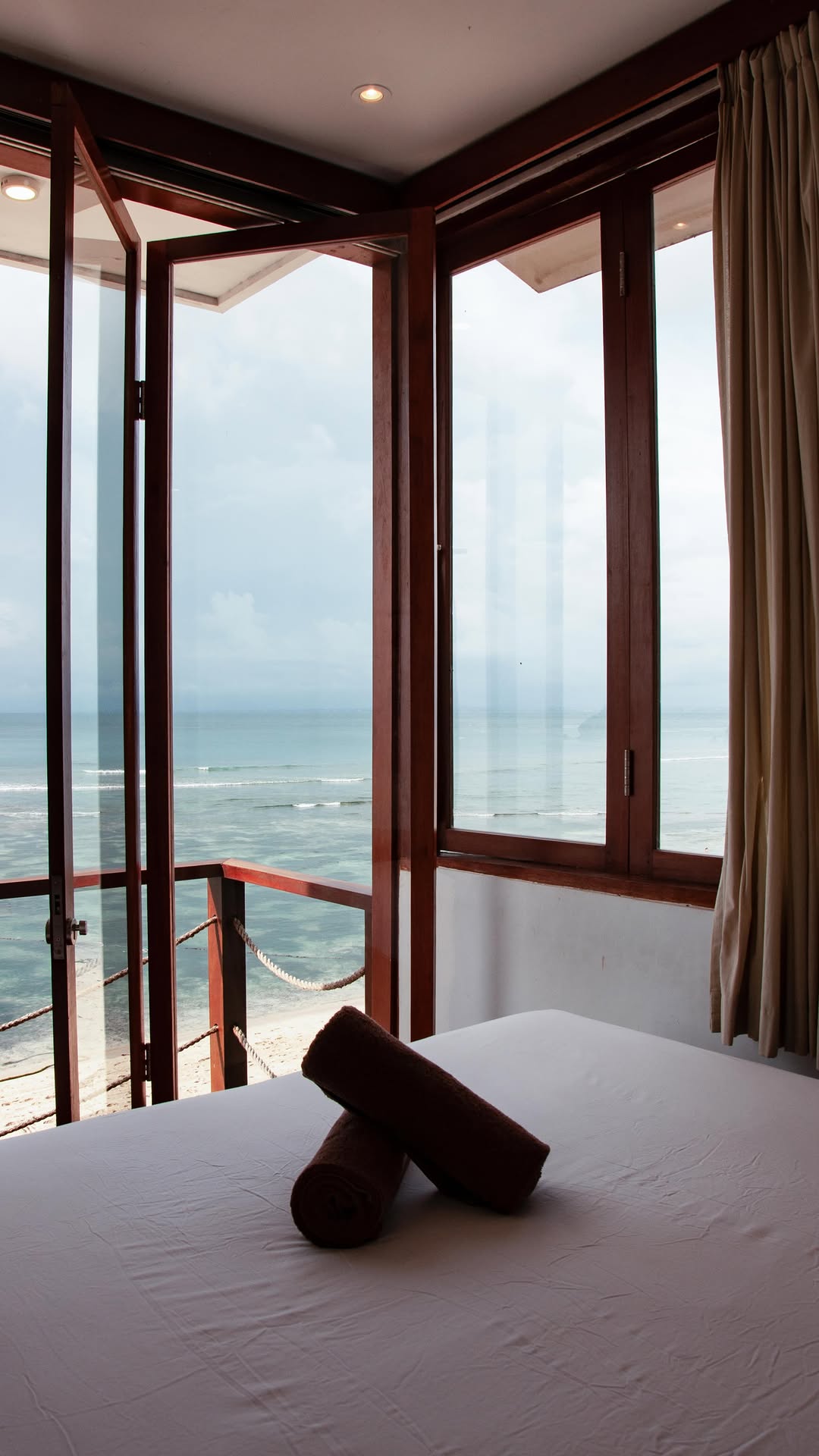 Ohm room with folding timber doors opening directly onto the ocean